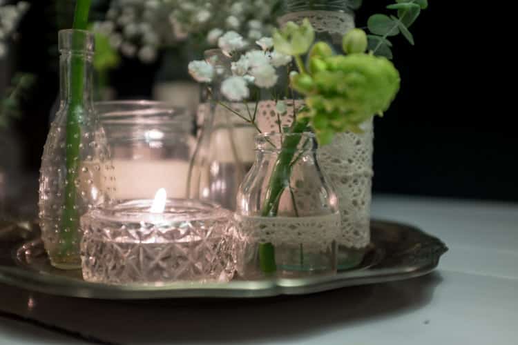 sylteglas med blonder og blomster på sølvfade