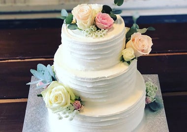 Hvid bryllupskage med friske roser