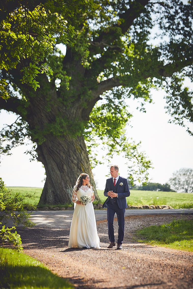 brudepar-foran-stort-træ