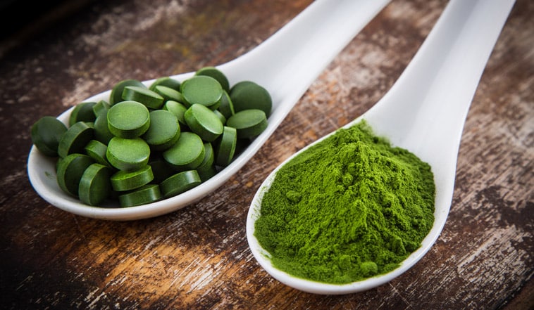 chlorella pulver og tabletter på skeer