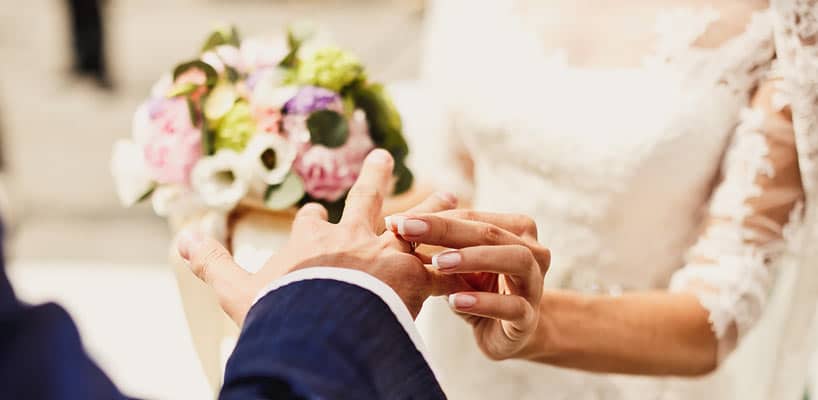 brud sætter ring på goms finger